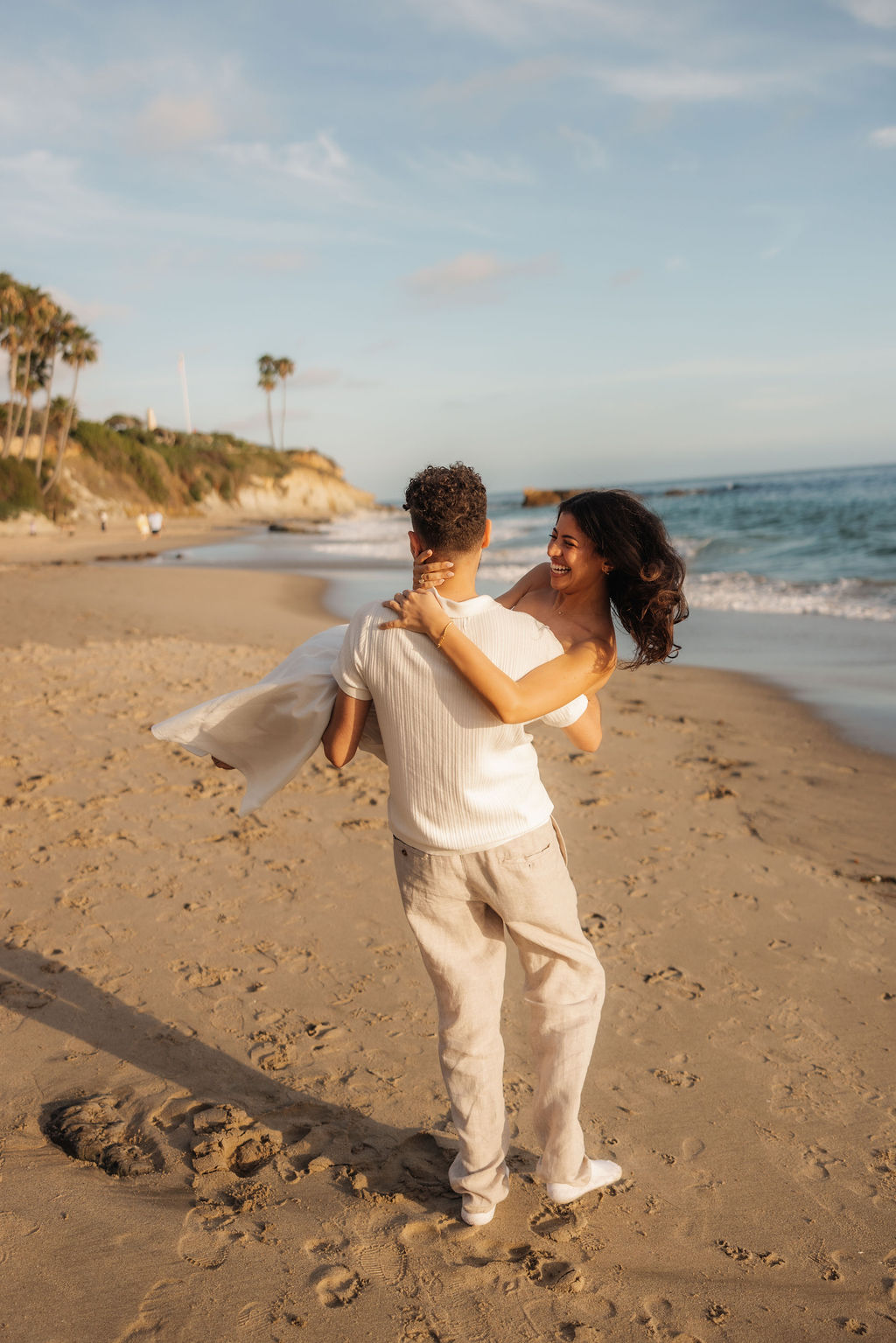 Candid and fun couple romantics on the sand at sunset by Santa Barbara proposal photographer
