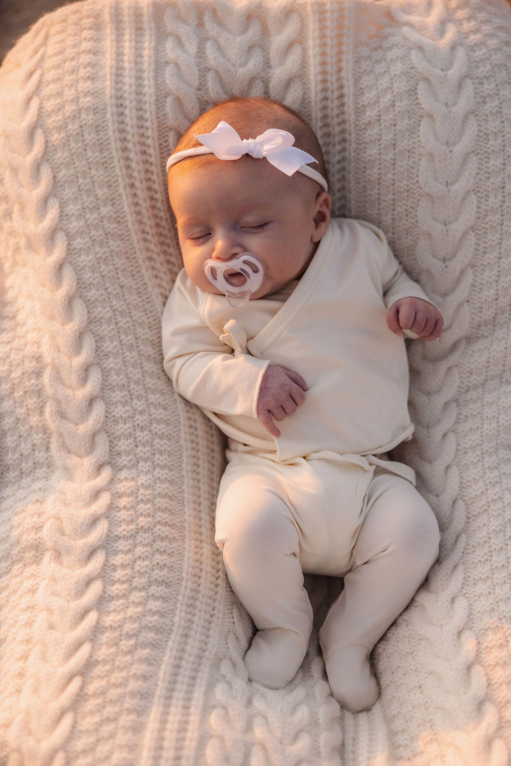 Close up of a perfect newborn baby girl at a golden hour coastal photo shoot