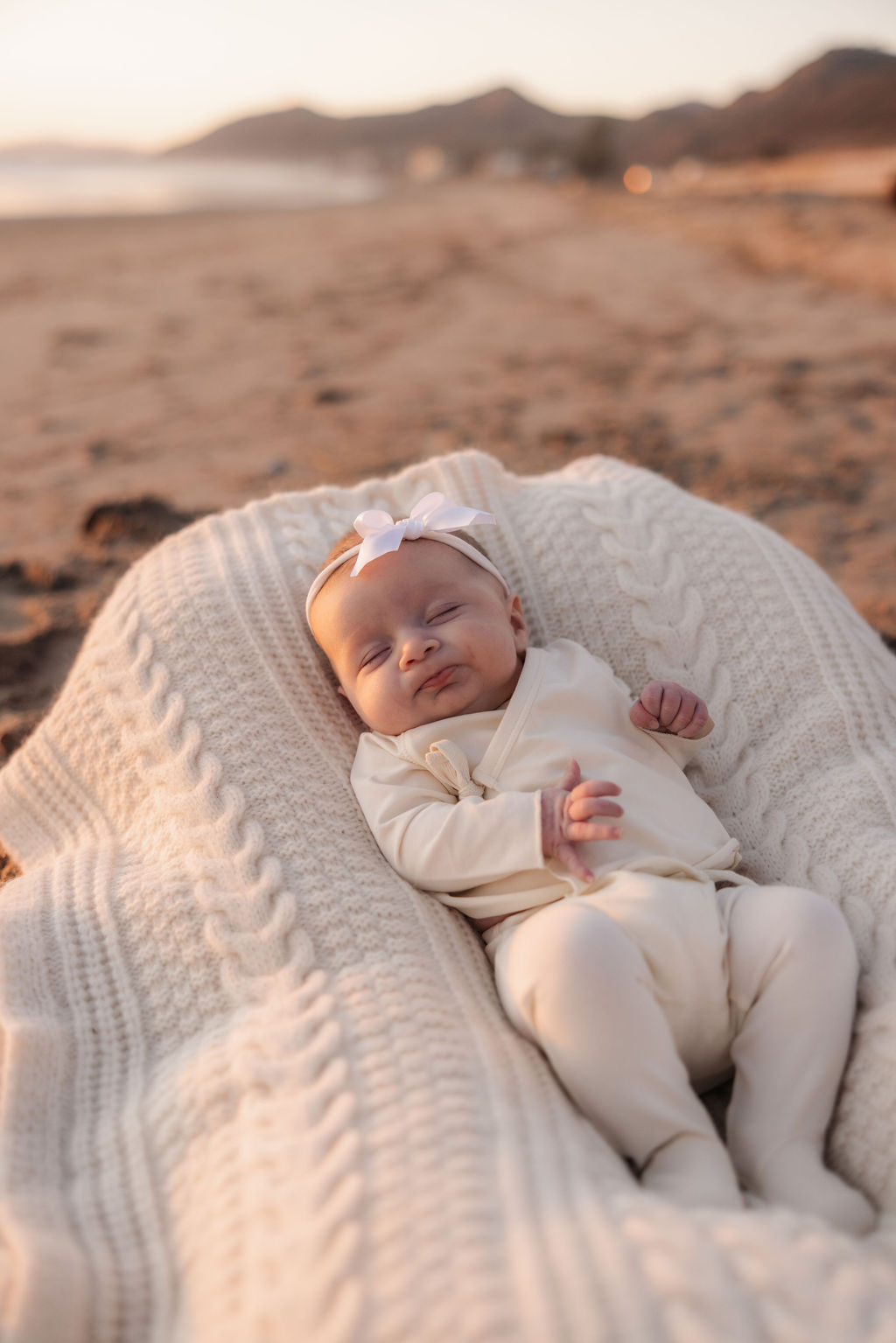 Newborn baby girl sleeping peacefully on a blanket at a Ventura beach