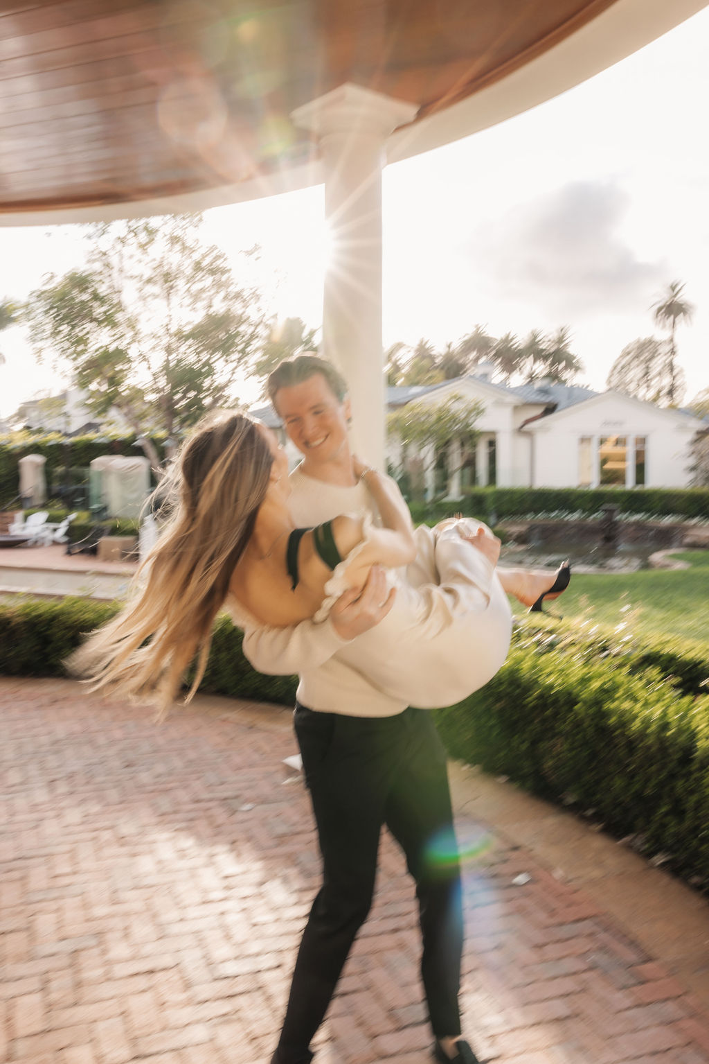 Fun candid lift and embrace celebrating a successful surprise marriage proposal