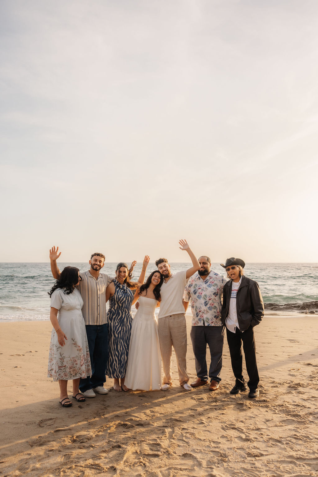 Sammy and Sarah celebrating with family on the coast after getting engaged by proposal photographer Ventura