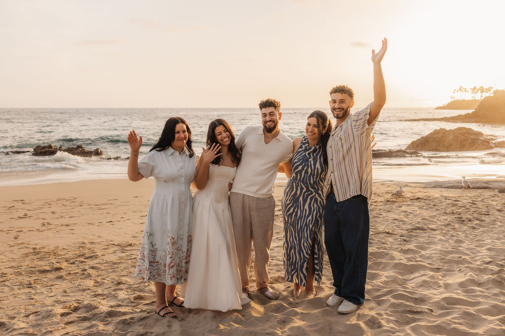 Sammy and Sarah posing with both of their families after saying yes by Santa Barbara proposal photographer
